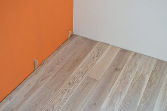 Realizace dubové podlahy v odstínu PARKETO - VIOLA s obklady ze sibiřského modřínu